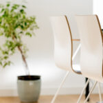 Nahaufnahme Behandlungszimmer mit hellen Stühlen und einer Grünpflanze