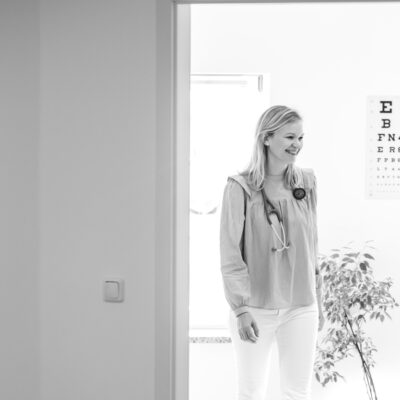 Graustufenbild Blick durch die Tür auf Dr. Janina Ledderose, welche durch den Raum läuft